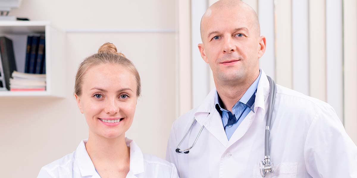 женщина врач в белом халате со стетоскопом в руке
